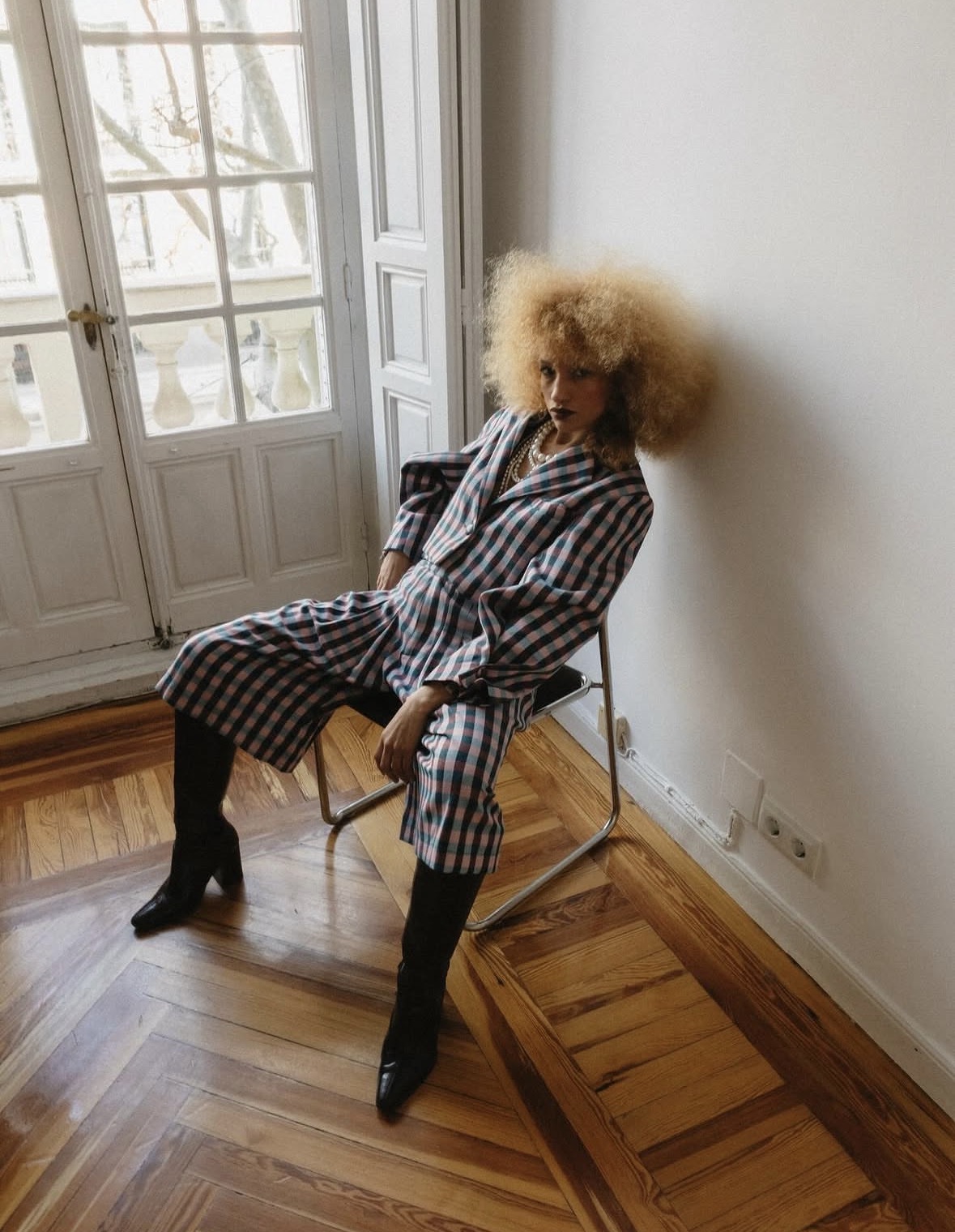 Nalu seated indoors in a checked outfit.