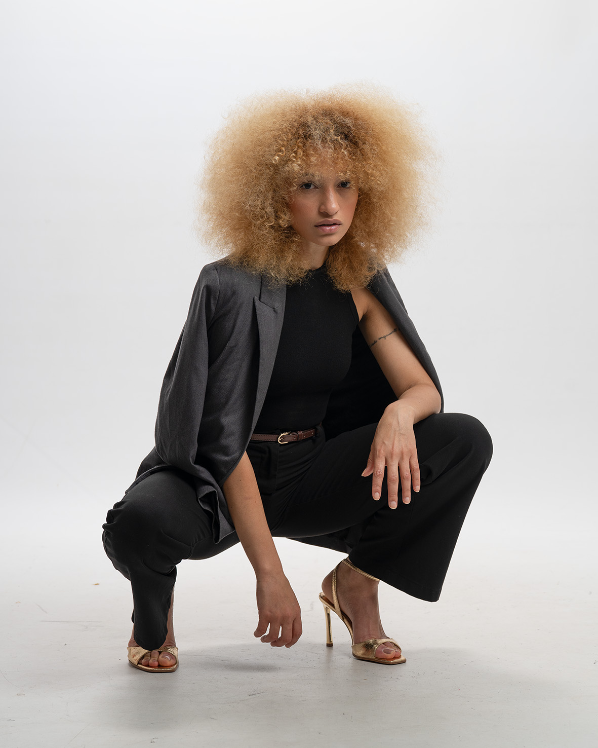 Nalu seated in a black look against a light studio background.