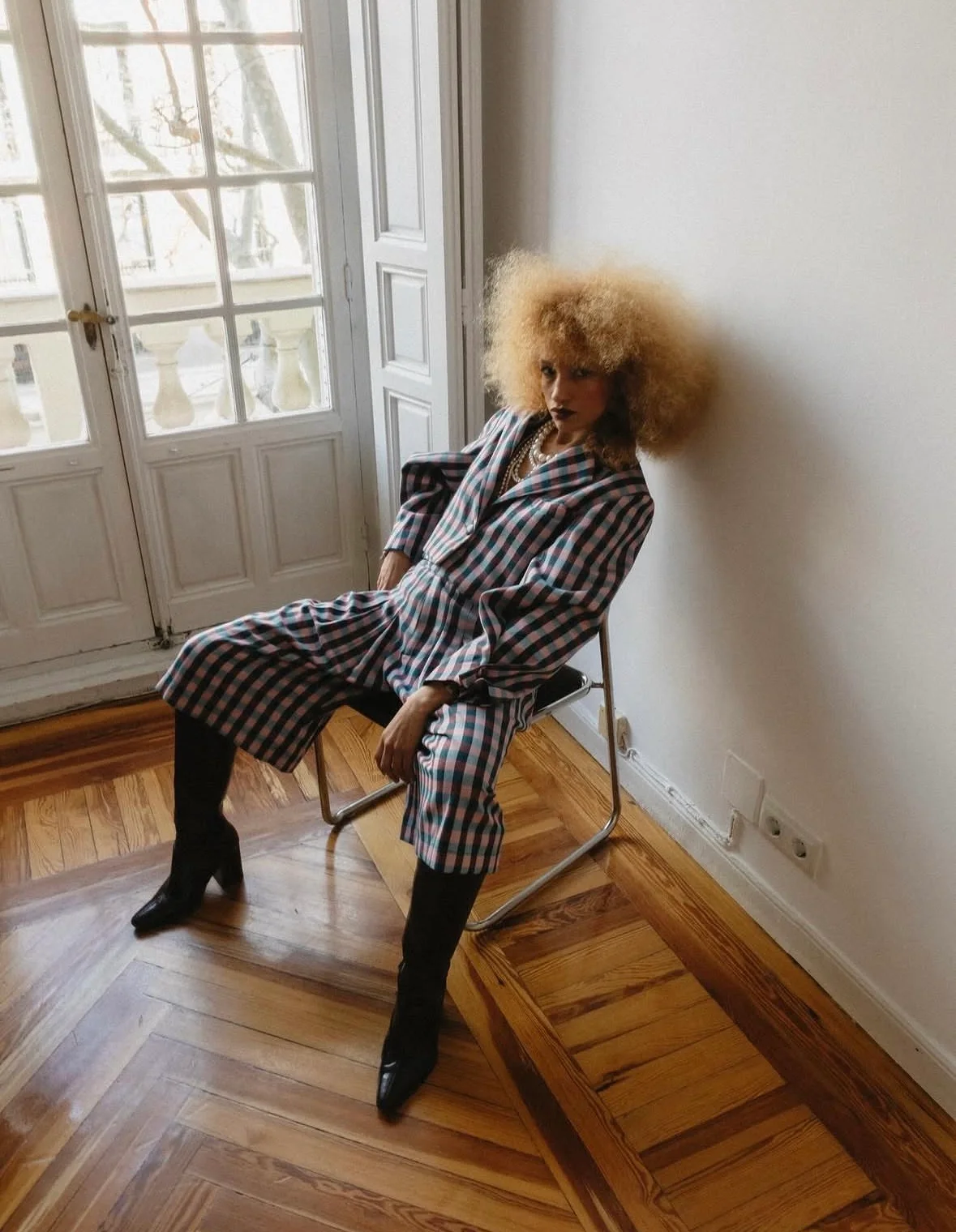 Nalu seated indoors in a checked outfit.